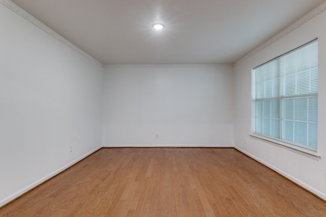 unfurnished room featuring crown molding and light wood-type flooring