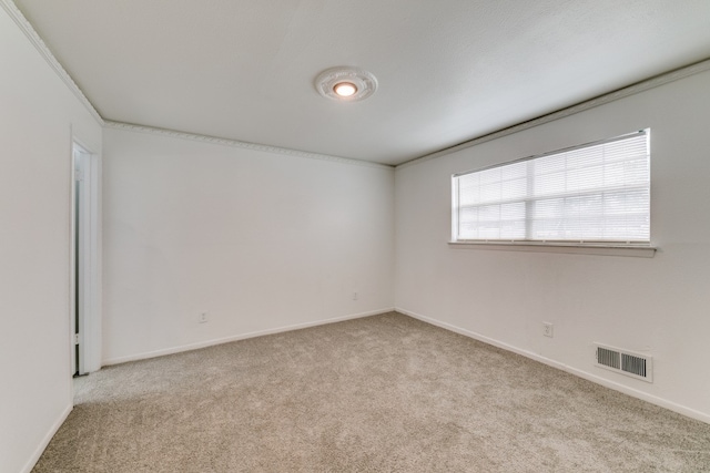 carpeted spare room featuring crown molding