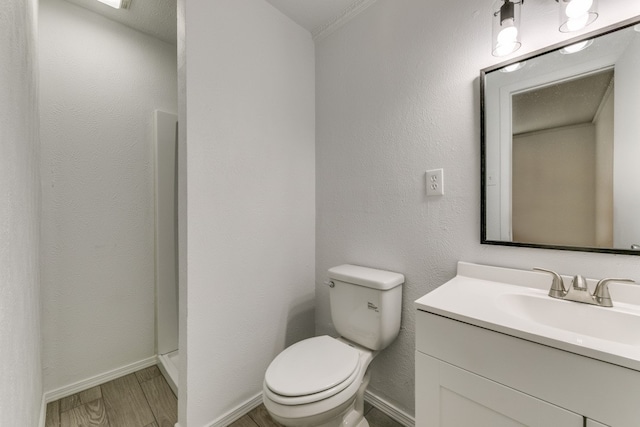 bathroom with wood-type flooring, toilet, and vanity