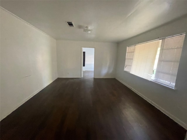 empty room with dark hardwood / wood-style flooring