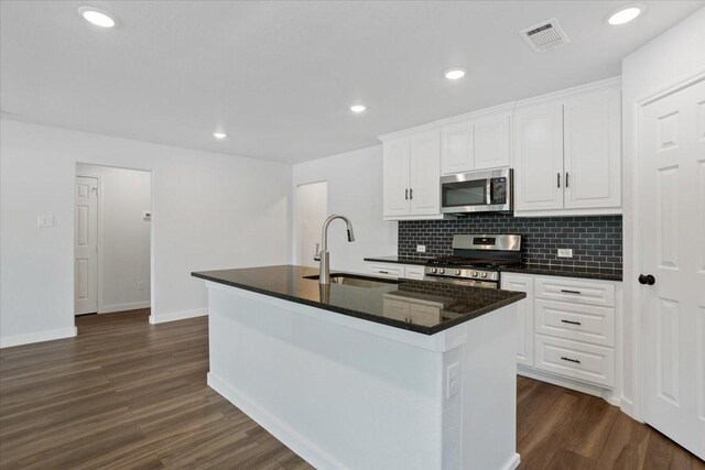 kitchen with dark wood-type flooring, sink, a center island with sink, and stainless steel appliances