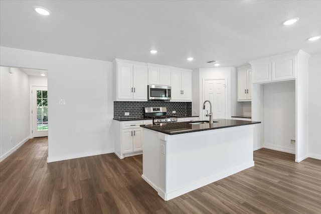 kitchen featuring white cabinetry, a center island with sink, dark hardwood / wood-style floors, and stainless steel appliances