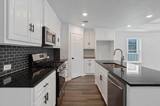 kitchen with white cabinets, stainless steel appliances, sink, and dark wood-type flooring