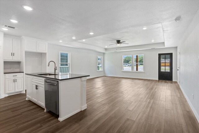 kitchen featuring stainless steel dishwasher, hardwood / wood-style flooring, ceiling fan, sink, and a raised ceiling