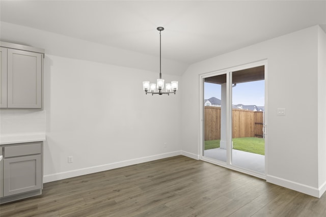 unfurnished dining area featuring dark hardwood / wood-style floors and a notable chandelier