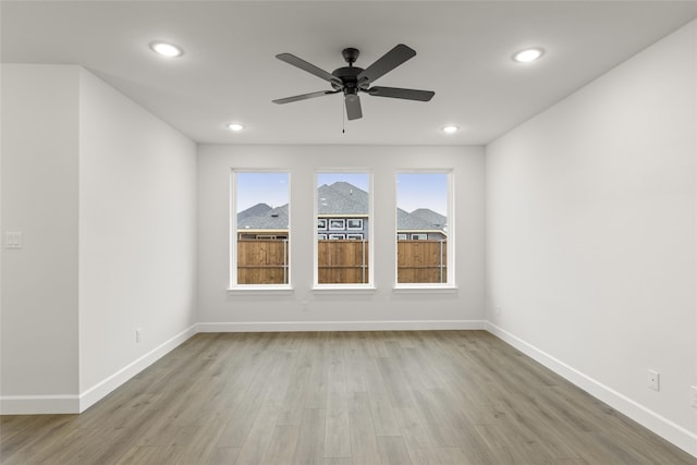 empty room featuring ceiling fan and light hardwood / wood-style flooring