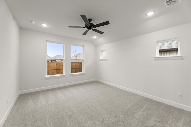 spare room featuring ceiling fan, light colored carpet, and lofted ceiling