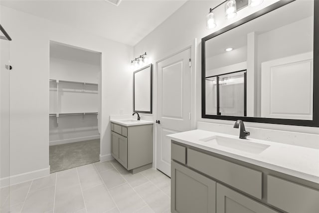 bathroom with tile patterned flooring, vanity, and a shower with door