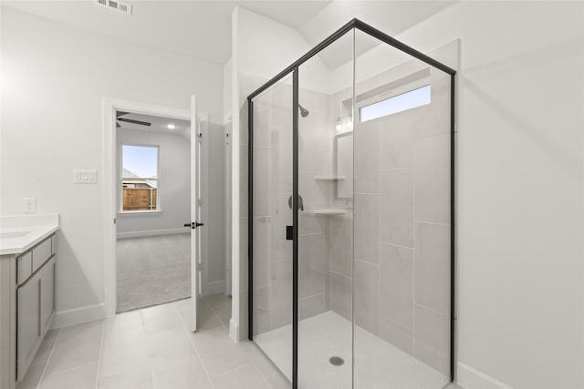 bathroom with tile patterned floors, plenty of natural light, vanity, and a shower with door