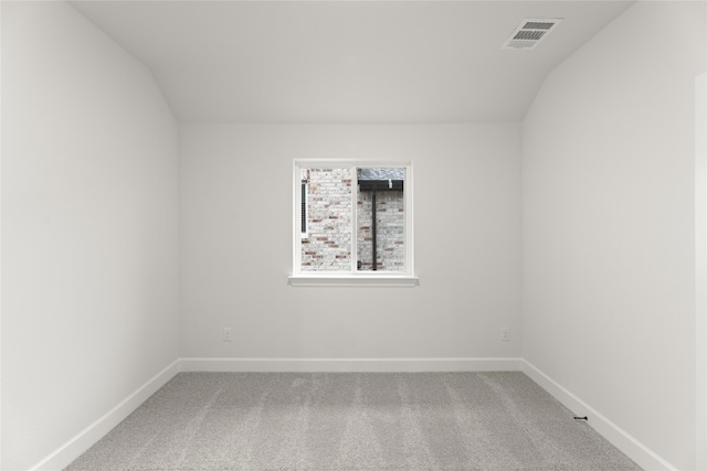 empty room featuring carpet flooring and lofted ceiling