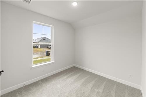 unfurnished room with carpet and lofted ceiling