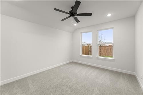 carpeted spare room with ceiling fan