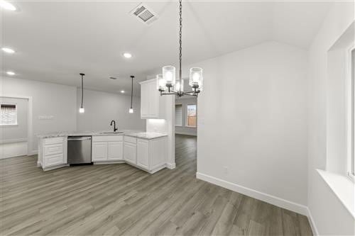 kitchen with dishwasher, white cabinets, decorative light fixtures, light hardwood / wood-style flooring, and plenty of natural light