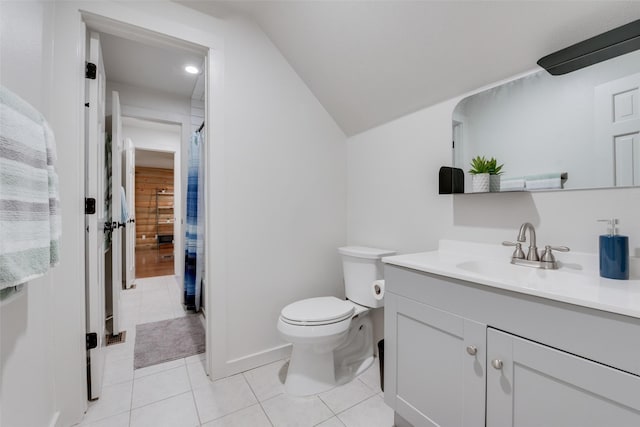 bathroom with lofted ceiling, vanity, toilet, and tile patterned flooring