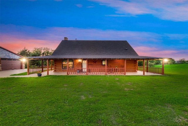 back house at dusk with a yard and a patio area