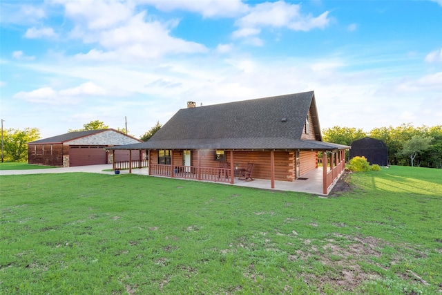 rear view of property with an outbuilding, a yard, and a garage