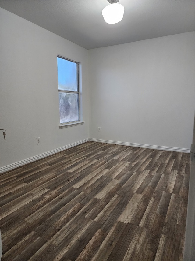 empty room with dark hardwood / wood-style flooring