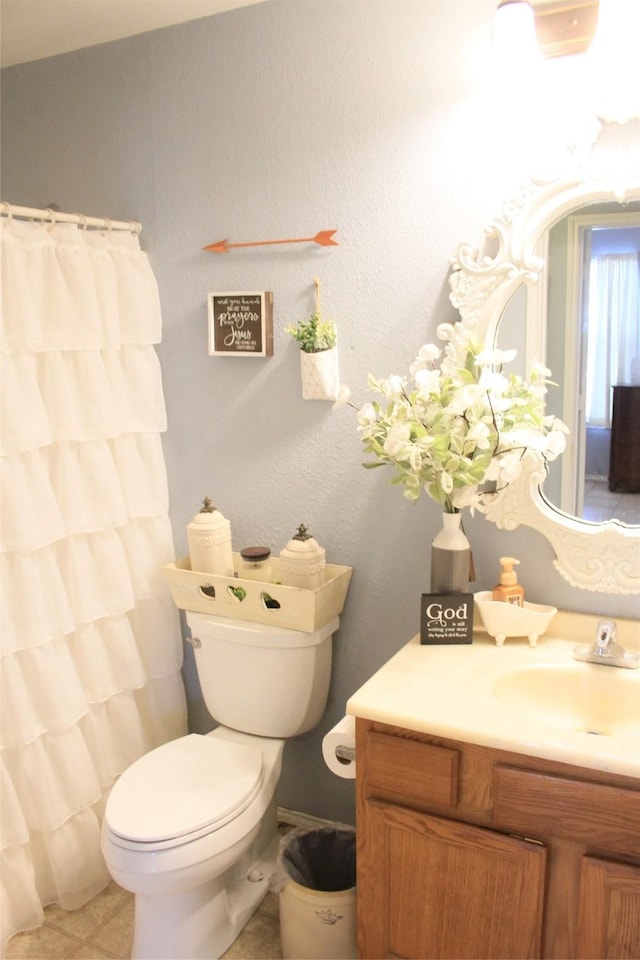 bathroom with tile patterned flooring, vanity, and toilet