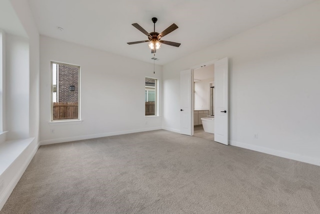 spare room featuring light carpet and ceiling fan