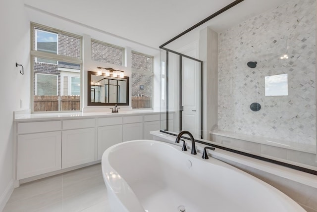 bathroom featuring tile patterned flooring, vanity, and shower with separate bathtub