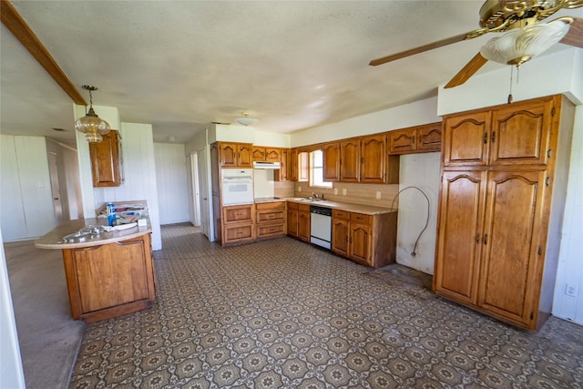 kitchen with ceiling fan, dark tile floors, white appliances, hanging light fixtures, and kitchen peninsula