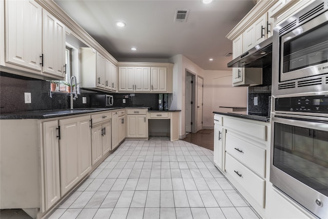 kitchen featuring ceiling fan, a fireplace, white cabinetry, dark hardwood / wood-style flooring, and pendant lighting