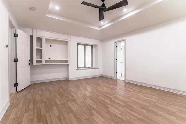 tiled spare room featuring ceiling fan and a raised ceiling