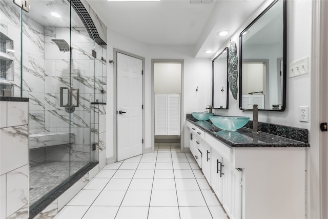 bathroom with a skylight, a shower with shower door, tile floors, and vanity