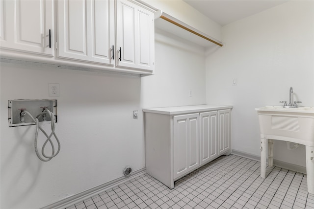 kitchen featuring light tile floors, appliances with stainless steel finishes, white cabinets, and sink