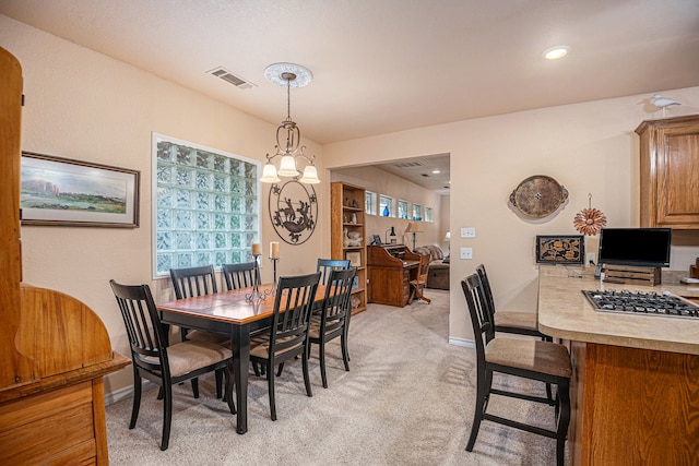 dining area featuring an inviting chandelier and light colored carpet