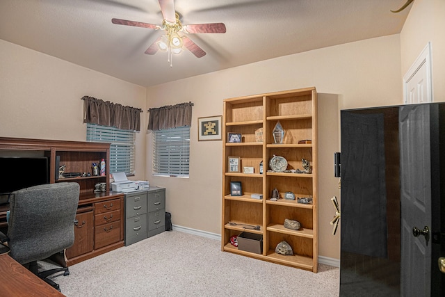 carpeted office space featuring ceiling fan