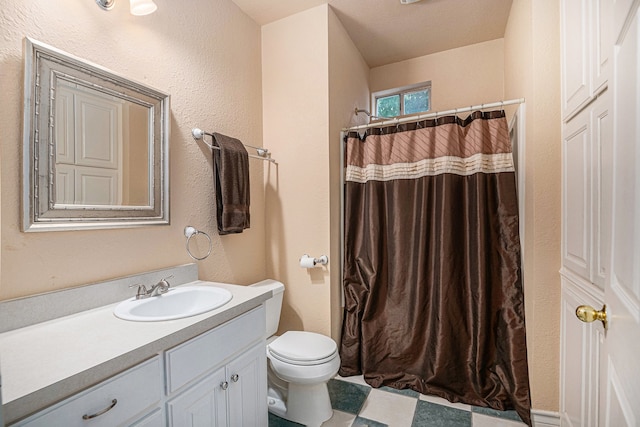 bathroom with vanity, toilet, and tile floors