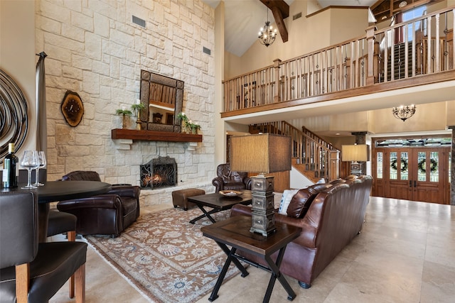 living room with beam ceiling, a stone fireplace, high vaulted ceiling, and a chandelier