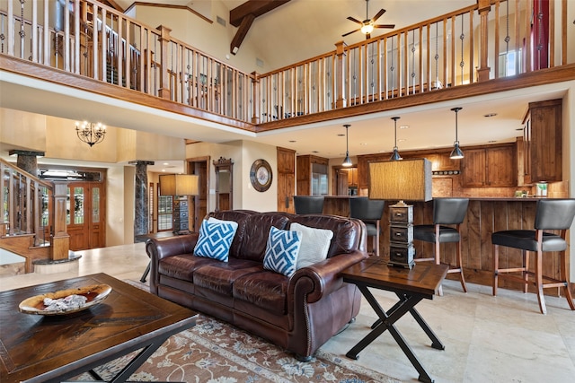 living room featuring a towering ceiling, ceiling fan with notable chandelier, and beam ceiling