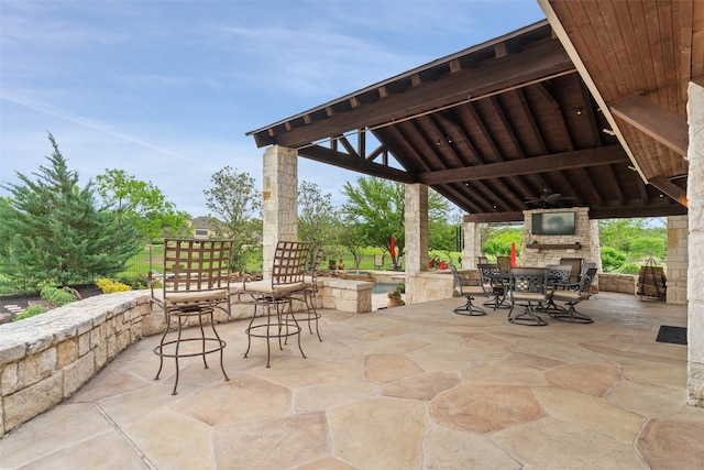 view of patio / terrace with an outdoor stone fireplace and a gazebo