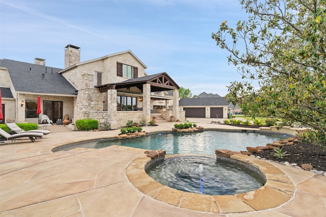 view of pool featuring a patio area and an in ground hot tub