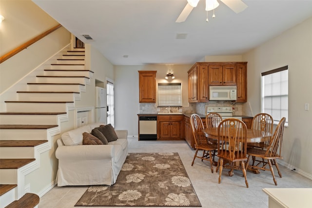 kitchen with white appliances, light tile patterned floors, backsplash, and ceiling fan