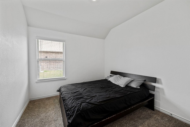 bedroom featuring dark carpet, vaulted ceiling, and multiple windows