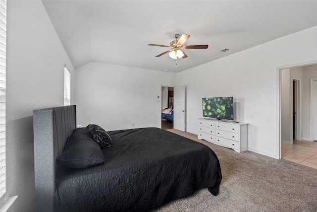 bedroom with ceiling fan, light tile floors, and lofted ceiling