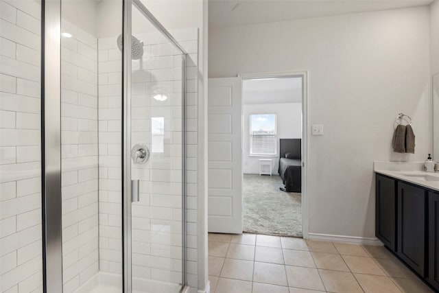 bathroom with a shower with door, tile flooring, and vanity