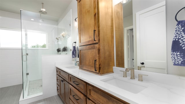 bathroom featuring vanity, a shower with shower door, and tile patterned flooring