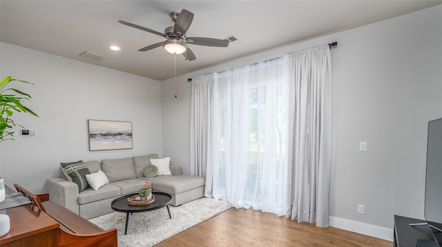 living room featuring ceiling fan and hardwood / wood-style floors