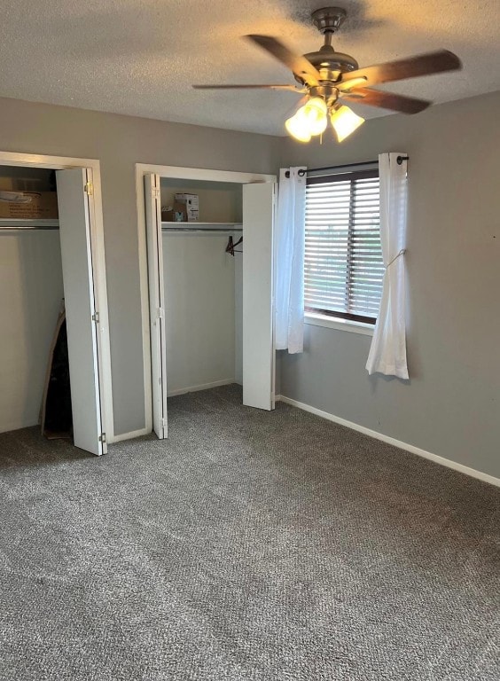 unfurnished bedroom with multiple closets, a textured ceiling, ceiling fan, and carpet