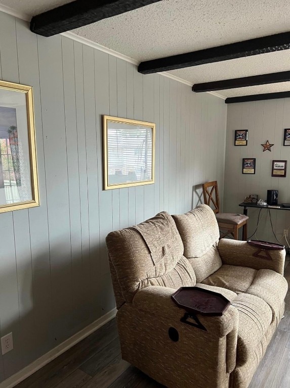 living room featuring beamed ceiling, dark hardwood / wood-style flooring, and a textured ceiling