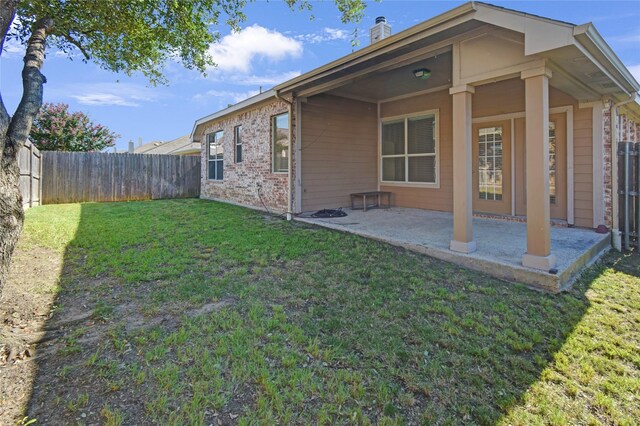 back of property featuring a patio area and a yard