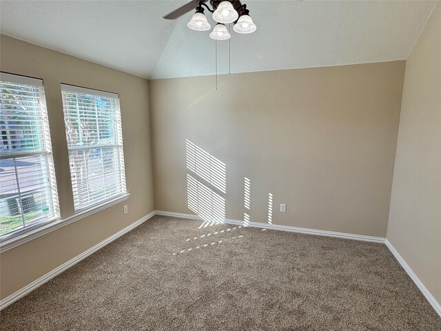 empty room with a textured ceiling, ceiling fan, carpet floors, and lofted ceiling