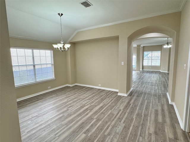 spare room with wood-type flooring, lofted ceiling, crown molding, and a notable chandelier