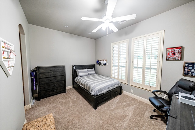 carpeted bedroom with ceiling fan and multiple windows