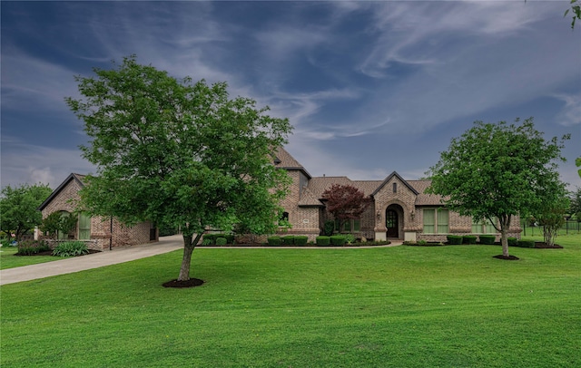 english style home featuring a front lawn