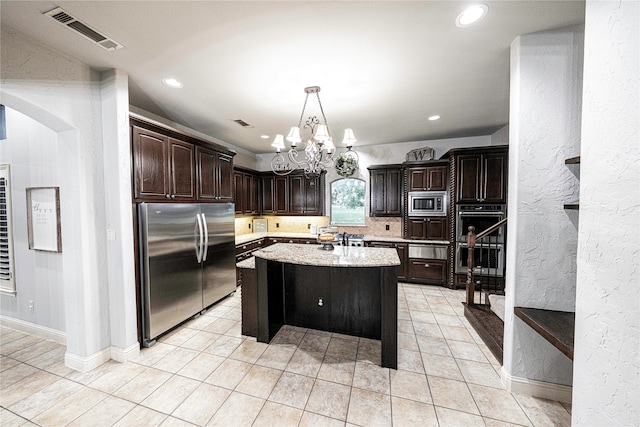 kitchen featuring dark brown cabinetry, appliances with stainless steel finishes, light tile floors, and a kitchen island